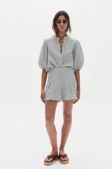 Short de lino con diseño a rayas en tonos celestes y blancos, con pinzas frontales y tiro alto.