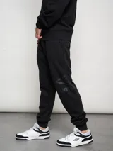 Pantalón de jogging azul marino de felpa con puños elásticos y logo de la marca estampado en la pierna izquierda.