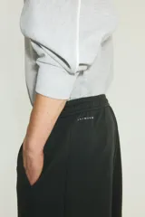 Jogger deportivo H&M de corte relajado, color negro, confeccionado en tejido funcional con tecnología DryMove. Cuenta con cintura elástica con cordón de ajuste, bolsillos laterales y diseño de piernas rectas.
