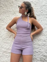 Mono corto de lurex color lila, con escote halter y espalda descubierta.