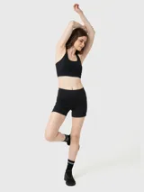 Calza corta deportiva de tiro alto, color negro, con ajuste al cuerpo y bolsillos laterales. Confeccionada en tejido suave con tecnología Aloe Vera y banda de silicona para mayor sujeción.