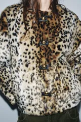 Chaqueta de Zara Woman Collection confeccionada en tejido efecto pelo con estampado animal print. Presenta cuello redondo, manga larga, bolsillos delanteros y cierre frontal con botones metálicos en relieve.