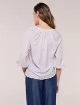 Blusa de gasa liviana blanca con estampado floral en tonos azules y rosados, escote en V, mangas 3/4 abullonadas con puños elásticos y corte fluido.