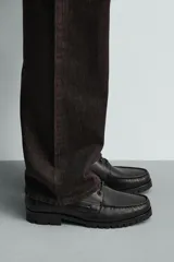 Zapato náutico de piel color negro, con cordones y suela dentada tipo track.