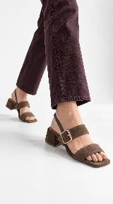 Sandalia de cuero color beige con taco cuadrado de 4 cm, tiras delanteras, tira ajustable con hebilla metálica dorada y tira elástica trasera.