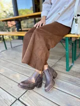 Botas cortas de cuero con efecto desgastado en color chocolate, con taco cuadrado y plataforma. Presentan cierre lateral y punta redondeada.