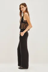 Pantalon palazzo de tiro alto, confeccionado en tejido de cupro con textura sedosa. Presenta una caída fluida, corte recto y bolsillos laterales.