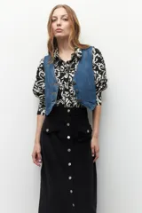 Maxifalda color borgoña de pana con botones metálicos al frente y cuatro bolsillos, dos de ellos con solapa.