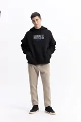 Canguro blanco de corte oversize con capucha y cordones ajustables. Presenta un estampado frontal con el texto 'BRIGHT FUTURE' en contorno azul y el logo de la marca en color naranja. Incluye bolsillos laterales.