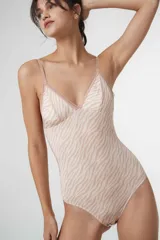 Body colaless de microfibra gloss con estampado de cebra en tonos beige y rosado. Presenta copas triangulares con bordes de puntilla, relleno extraíble, cierre en la entrepierna con broches de presión y breteles ajustables.