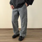 Pantalón de jean con corte baggy, de color gris con efecto lavado y estampado sutil en tono verdoso.