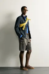 Bermuda cargo color verde militar de corte relaxed fit, confeccionada en tejido de algodón. Cuenta con bolsillos laterales con solapa en las perneras, trabillas en la cintura con ajuste lateral y cierre frontal con cremallera y botón.