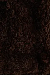 Campera corta de textura efecto peludito en color marrón oscuro. Presenta cuello alto, cierre frontal, bolsillos delanteros con solapa y puños y bajo en punto acanalado.