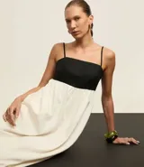 Vestido evasé midi de viscolino, con escote recto y breteles finos. Diseño bicolor con busto negro y falda blanca.
