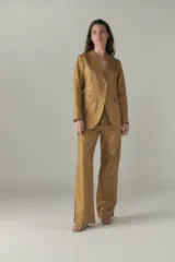 Blazer color dorado con ruedo curvo, bolsillo ojal con tapita y tajo en la espalda.