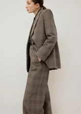 Blazer de corte sastrero con diseño a cuadros, confeccionado en una mezcla de lana, poliéster, viscosa y elastano. Presenta solapas clásicas, cierre frontal con un botón y bolsillos laterales con solapa.