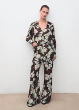 Pantalón de tiro medio con cintura elástica sin cierre, corte flare y diseño largo con forro interior. Presenta un estampado floral en tonos marrones y verdes.