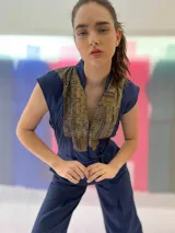 Mono largo azul marino con estampado dorado en la parte superior, cuello mao, sin mangas, con cinturón y bolsillos laterales.