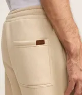 Pantalón de corte recto confeccionado en tejido de algodón y poliéster, con cintura elástica ajustable mediante lazo y bolsillos laterales.