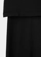 Pantalón de punto fino color negro, de diseño recto y tiro medio, con falda corta superpuesta integrada.