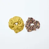 Pack de dos coleteros para el pelo, uno de color dorado y otro con estampado animal print en tonos marrones.