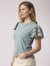 Remera blanca de poliéster y spandex con mangas cortas con volados de encaje.