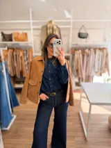 Chaqueta de estilo clásico con acabado efecto gamuza, confeccionada en algodón. Presenta cierre frontal con botones, cuello camisero y dos bolsillos delanteros con solapa. Posee interior forrado y corte recto.