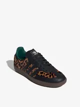 Championes Adidas Samba OG con estampado de guepardo, detalles en cuero negro, forro interior verde y suela marrón. Zapatilla de corte bajo con cordones negros y las tres tiras características de Adidas en cuero negro.