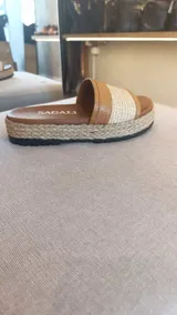 Sandalias planas con capellada de rafia y cuero color suela, suela revestida en yute trenzado y plataforma de 4 cm.