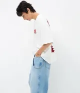 Pantalón de jean modelo skater, de corte holgado y tiro medio, con diseño de cinco bolsillos y detalle de cordón decorativo en la cintura.