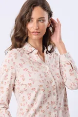 Camisa de jersey de algodón color beige con estampado floral en tonos rosados y marrones, cuello camisero, manga larga con puños abotonados y cierre frontal con botones.