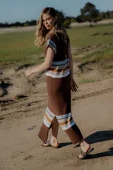 Vestido tejido marrón con rayas horizontales en blanco, celeste y naranja.