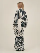 Pantalón ancho con estampado floral en tonos verde y blanco, con pinzas en el frente, bolsillos laterales y elástico en la cintura.