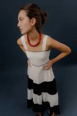 Vestido largo de diseño tricolor con bloques horizontales en blanco y azul marino, tirantes anchos y falda amplia en capas.