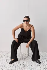 Top negro de breteles finos con escote en V y diseño minimalista, confeccionado en tela fluida y suave.