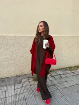 Ruana negra de tejido liviano con terminación de flecos en el ruedo y mangas amplias.