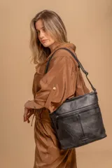 Bandolera mediana de cuero sintético color negro, con correa regulable, bolsillo frontal con cierre y compartimento principal.