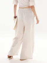 Pantalón palazzo color beige, de corte pescador y cintura alta con cordón ajustable.