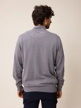 Sweater de punto color gris, con cuello alto y cierre frontal parcial con detalle de tela a cuadros en el interior. Presenta puños y ruedo acanalados y logo bordado en el pecho.
