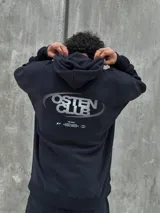 Canguro negro con capucha ajustable con cordones, bolsillo tipo canguro y logo "Osten Club" estampado en el pecho. Corte oversize.