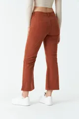 Pantalón de pana negro, de corte recto y tiro medio, con bolsillos y presillas para cinturón.