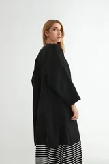 Saco tipo cárdigan largo de tejido de punto, color beige, con diseño abierto sin botones, mangas largas amplias y corte recto.