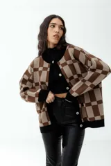 Cárdigan marrón con diseño a cuadros beige, con cuello, puños y borde inferior negros.