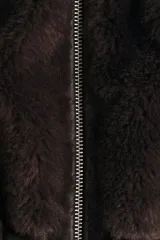 Abrigo de corte oversized confeccionado en tejido de efecto piel sintética suave. Presenta cuello elevado, cierre frontal con cremallera, hombros caídos, costuras visibles en los codos y bolsillos laterales al bies. Incluye forro interior.
