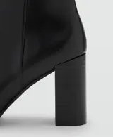 Botín de tacón bloque y punta fina, con cierre de cremallera lateral y acabado efecto piel.