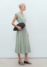 Vestido midi de color verde menta con cuello en pico y diseño evasé. Presenta mangas cortas, cierre de cremallera en la parte posterior y detalle de costuras verticales que definen la silueta.