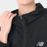 Campera deportiva New Balance de corte holgado, color negro, con cierre frontal, capucha y mangas largas con puños elásticos. Presenta el logo de la marca en el pecho.