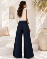 Jeans oxford de mezclilla azul oscuro, tiro alto, con bolsillos laterales y traseros, y perneras amplias y acampanadas.
