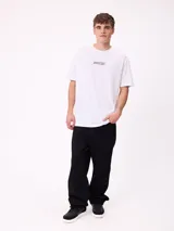 Remera de corte oversize, color blanco, con cuello redondo y logo de la marca estampado en el centro del pecho.