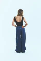 Jean de corte oversize confeccionado en denim de algodón con lavado azul clásico. Presenta tiro medio-bajo, cierre frontal con botón y bolsillos laterales.